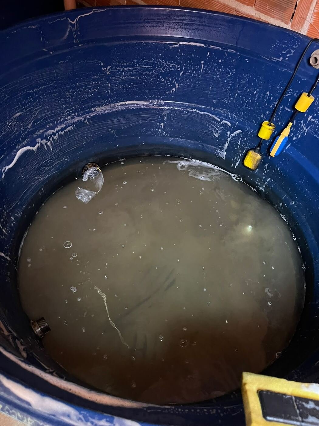 Caixa d'água sendo esvaziada e escovada durante a limpeza